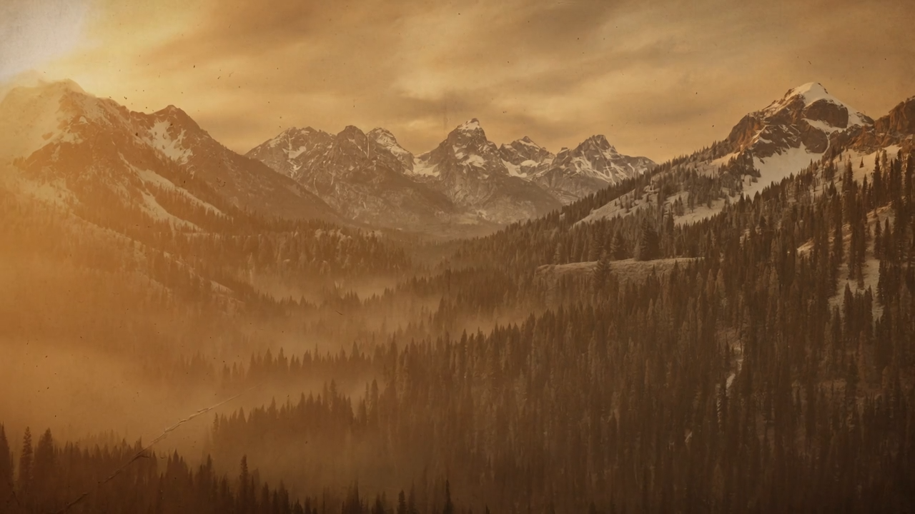 Aerial view of mountain peaks glowing at dawn, seen from the cockpit